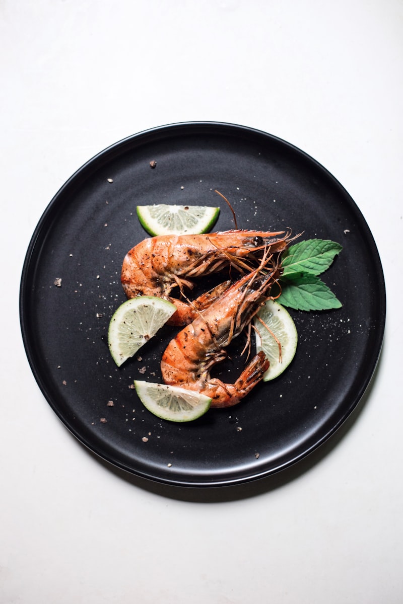 Jumbo shrimp on a dark plate with lemon